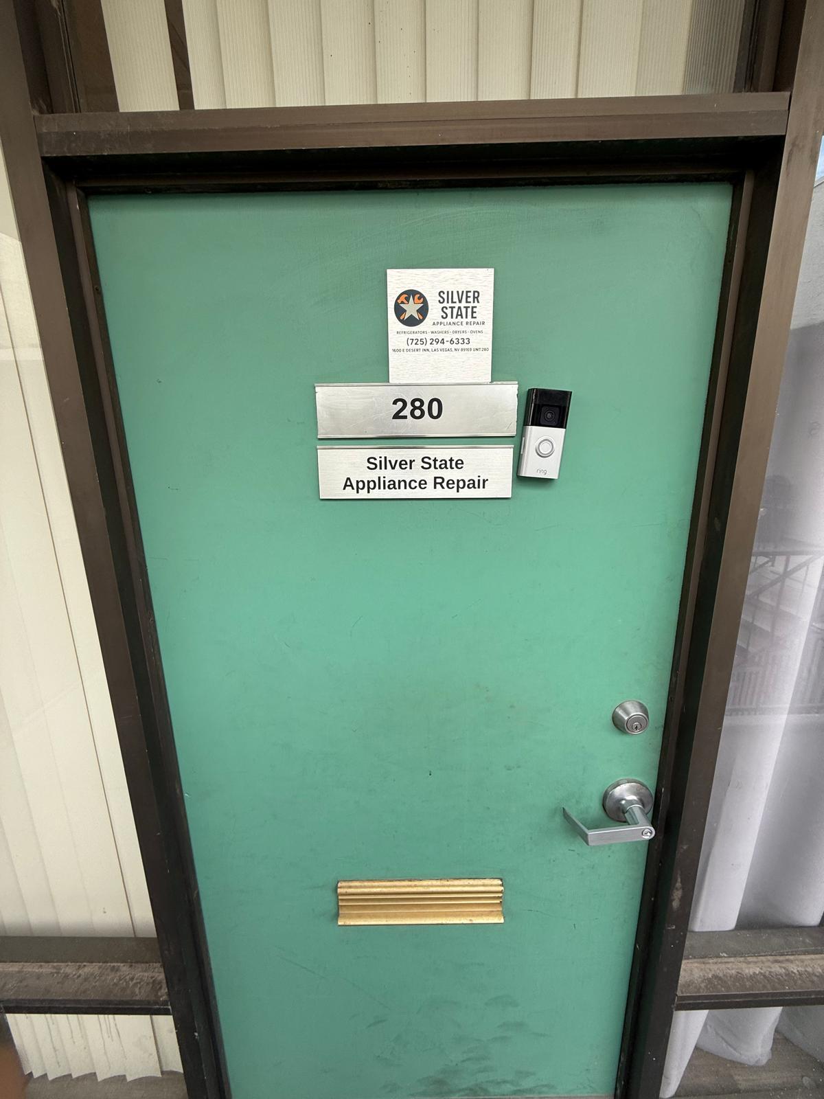 Green office door with Silver State Appliance Repair sign and unit number 280